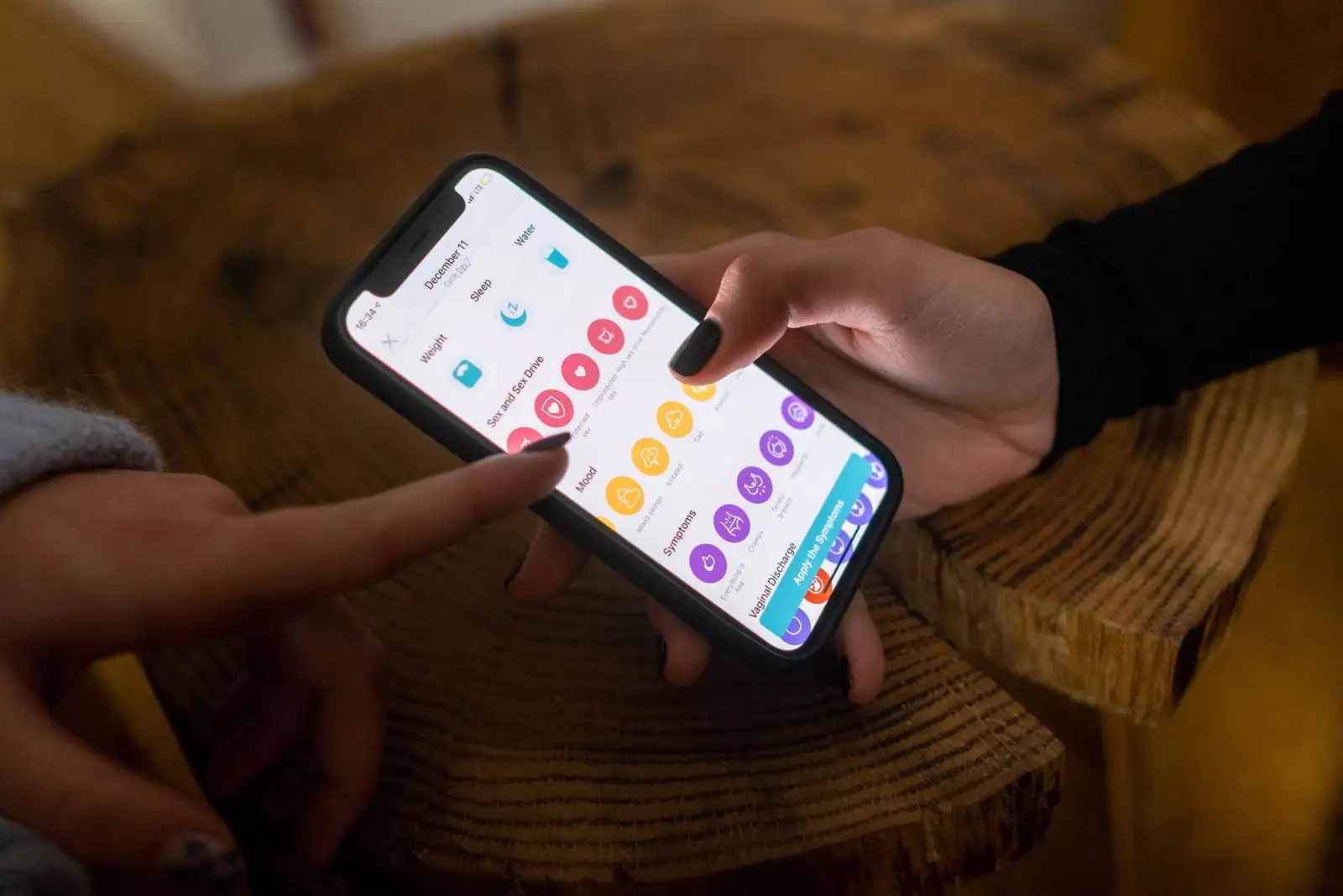 Smartphone tenu en main, affichant une application à l'écran.