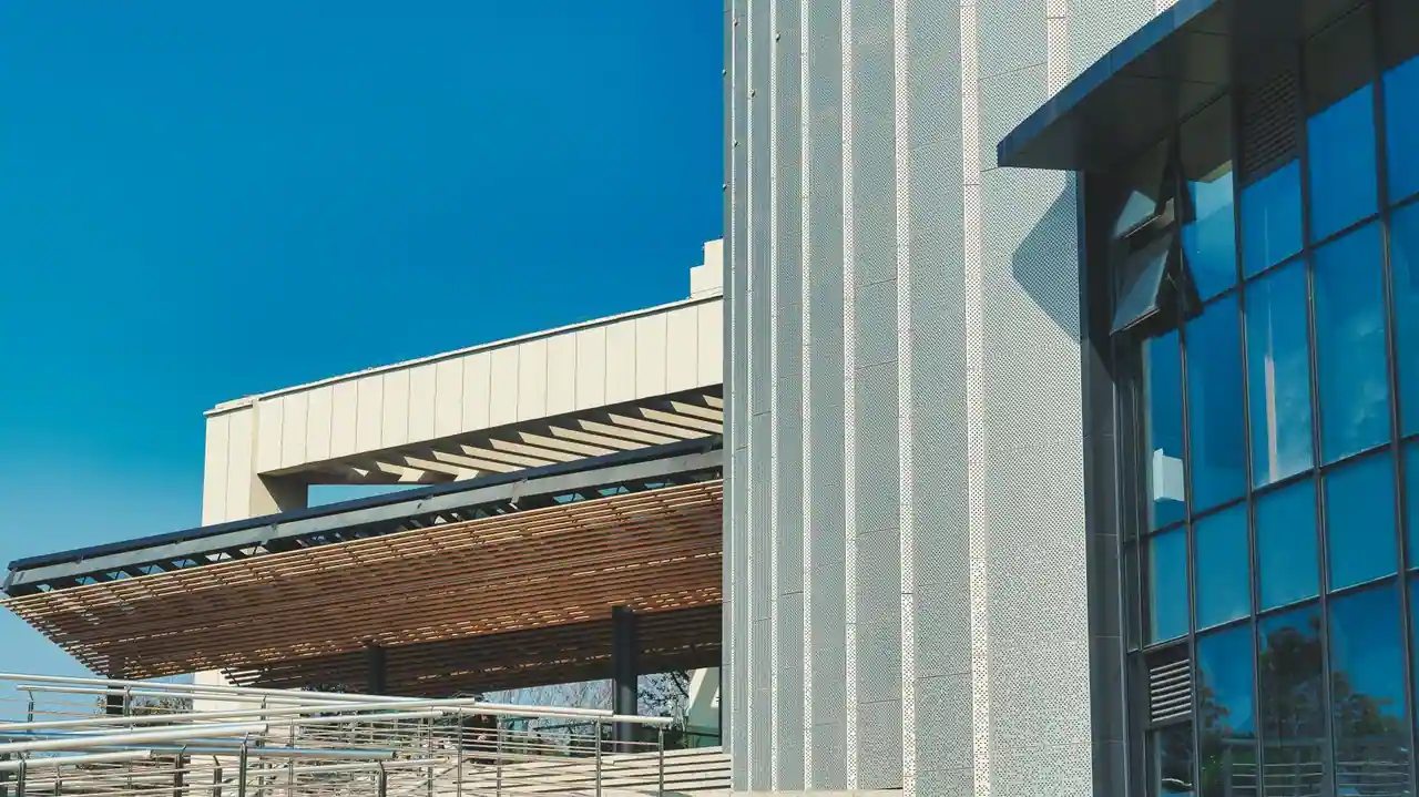 Façade d'un bâtiment contemporain en acier et verre dont la structure reste apparente