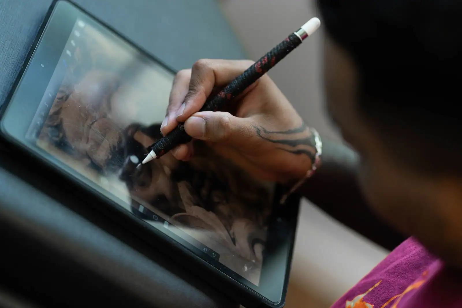 Main dessinant une illustration numérique sur une tablette graphique à l'aide d'un stylet