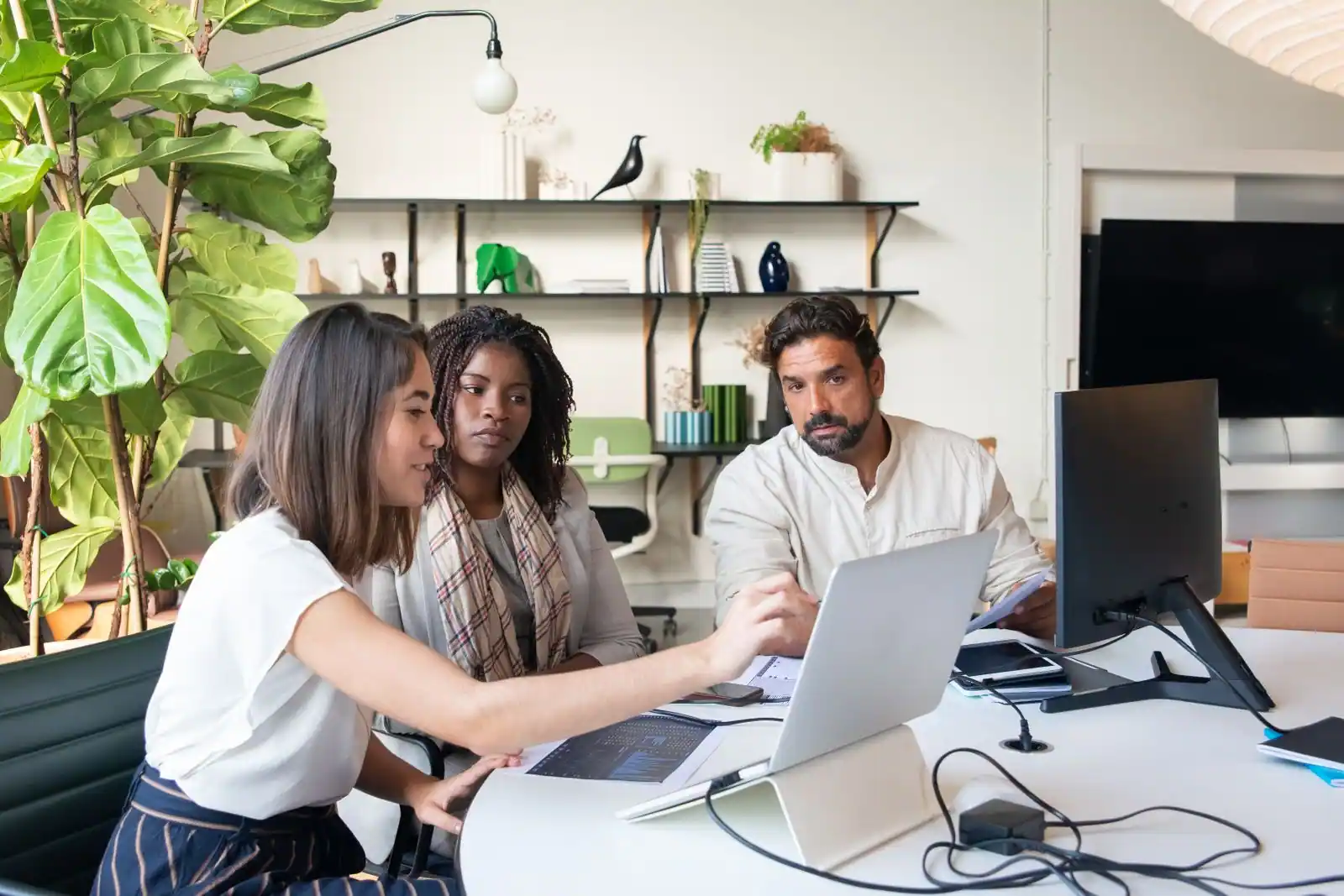 Équipe de travail réunie autour d'un ordinateur portable, collaborant sur un projet commun au bureau