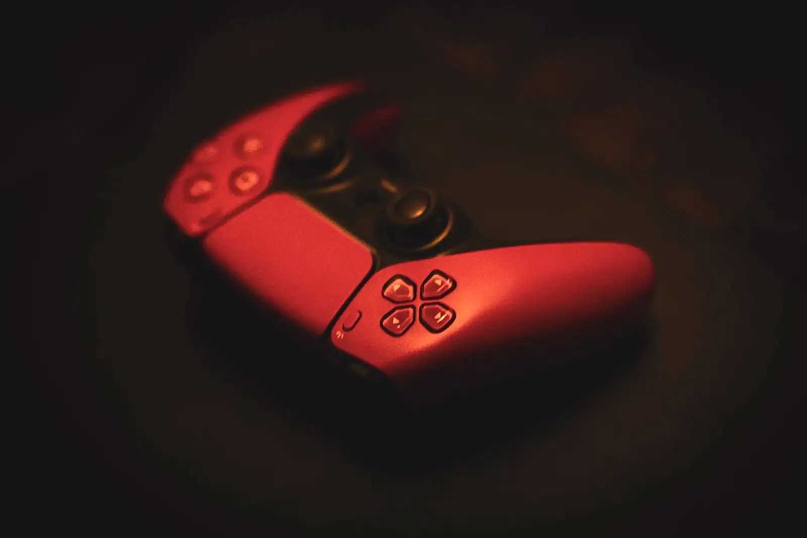 Manette de jeu sombre posée dans une lumière feutrée, image d'illustration sur le thème des consoles.