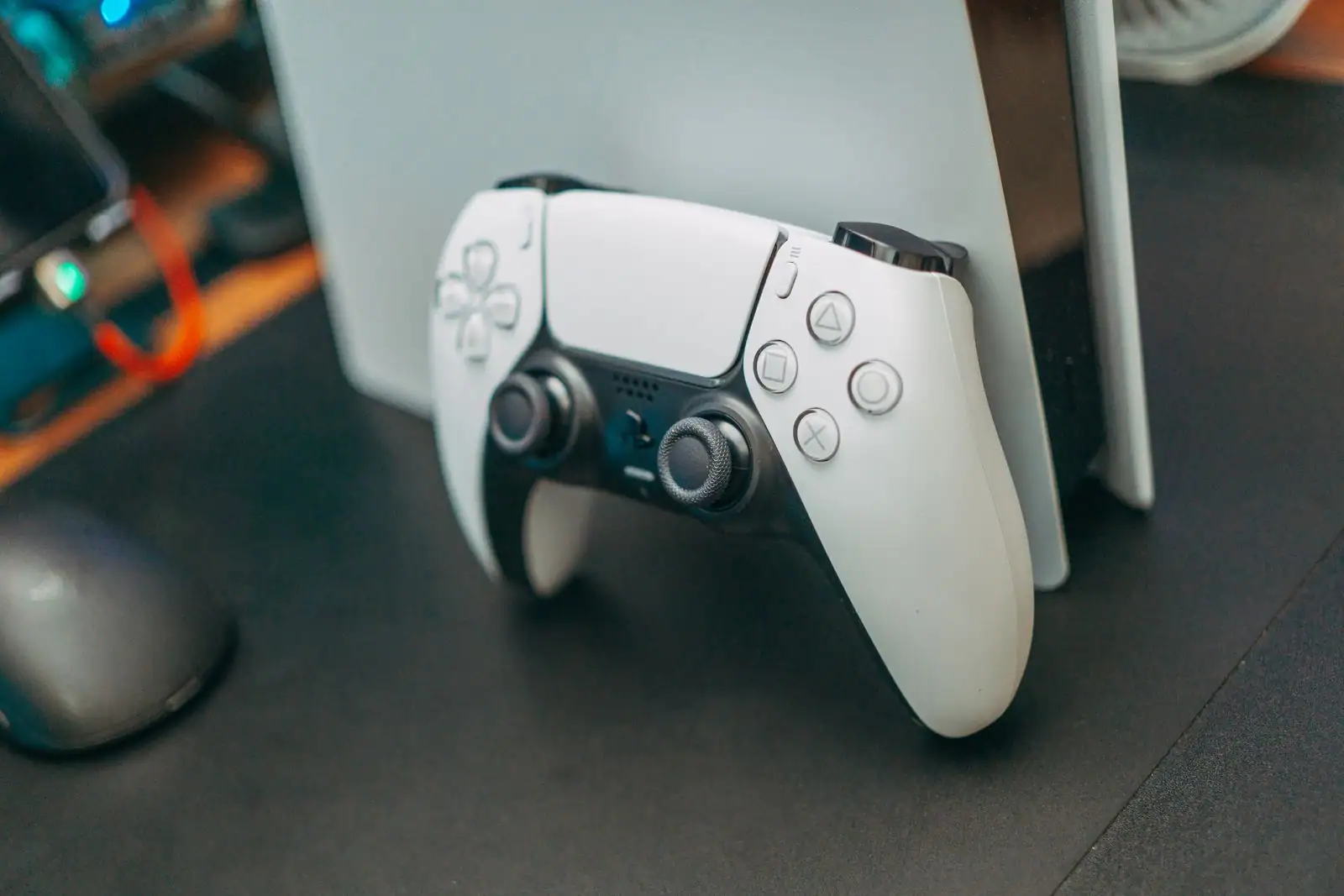 Manette blanche DualSense de PlayStation 5 appuyée contre la console.