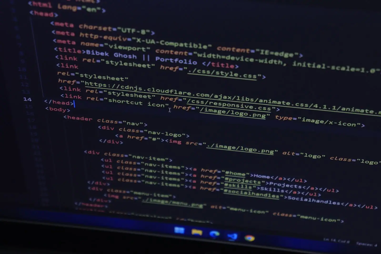 Code HTML d'un site web affiché sur un écran sombre, lors du développement du site.