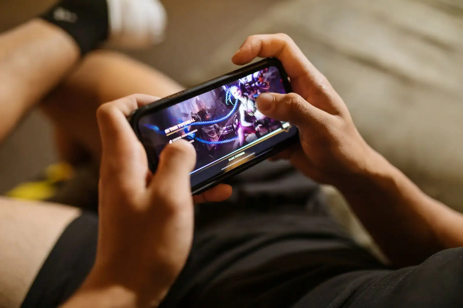 Personne jouant à un jeu vidéo sur un smartphone tenu à l'horizontale à deux mains