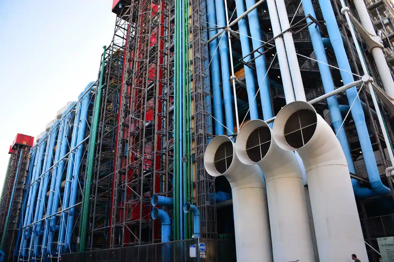 Façade technique du Centre Pompidou à Paris : gaines colorées, structure d'acier et tubes d'aération apparents.